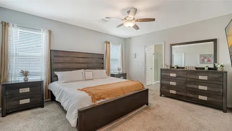 a bedroom with a bed a chandelier and a dresser