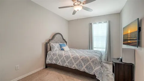 a bedroom with a bed and a flat tv screen on the dresser