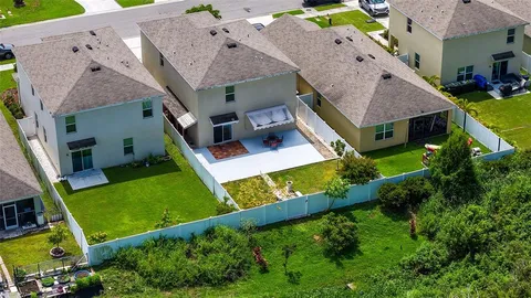an aerial view of residential house with outdoor space and trees