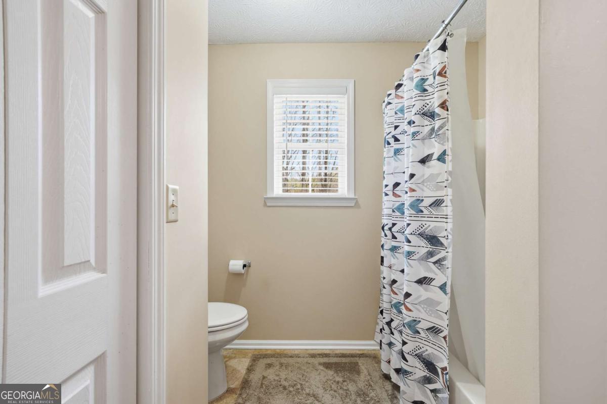 134 Nicholson Lane Talking Rock, GA 30175 - Photo 37 of 72 a bathroom with a toilet and a shower curtain