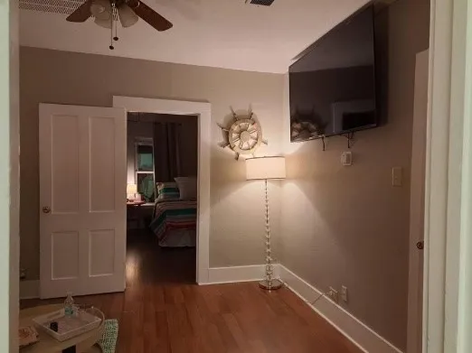 a view of a livingroom with wooden floor and a flat screen tv