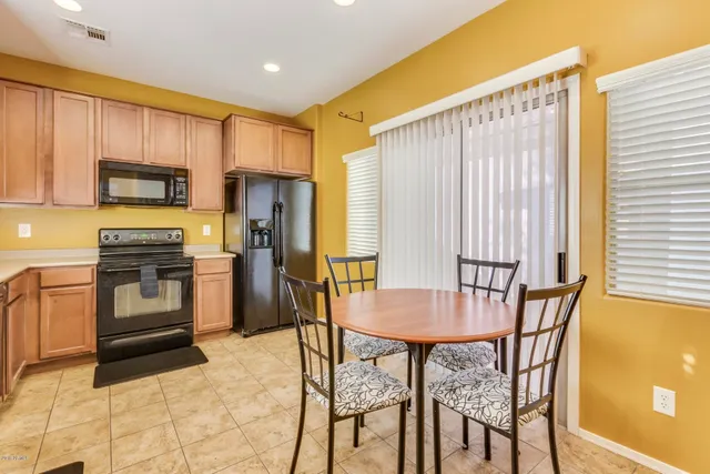 a kitchen with a table chairs microwave and refrigerator
