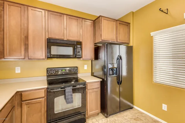 a kitchen with stainless steel appliances granite countertop a refrigerator and a stove top oven