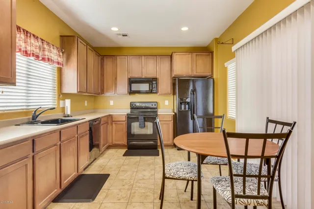 a kitchen with a table chairs sink and cabinets