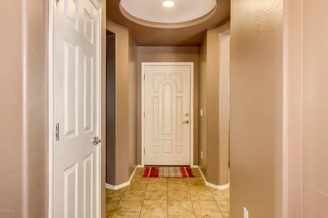 a view of a hallway with a door and a bathroom