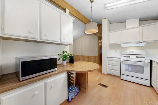 a kitchen with stainless steel appliances a stove microwave and cabinets