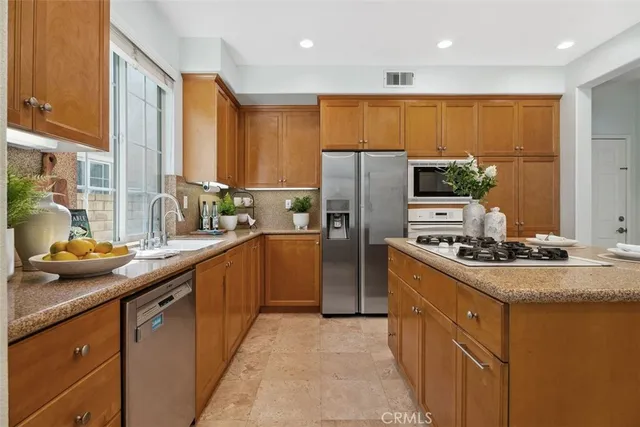a kitchen with stainless steel appliances granite countertop a sink stove and refrigerator