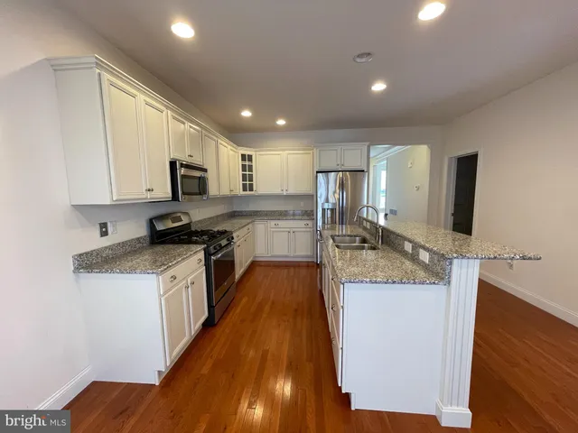 a large kitchen with granite countertop a sink and cabinets