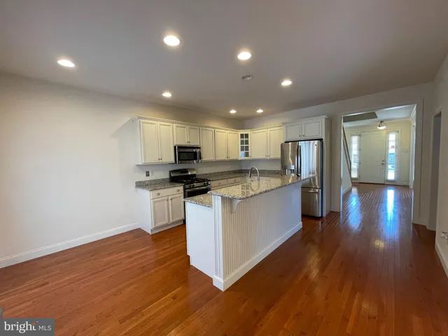 a kitchen with stainless steel appliances granite countertop a stove a sink and a refrigerator