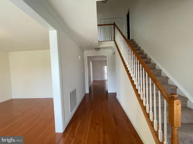 a view of a hallway with wooden floor and staircase