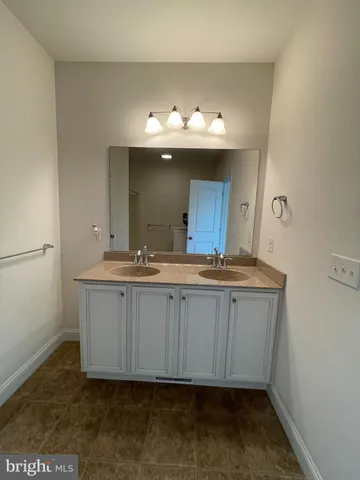 a bathroom with a sink vanity and a mirror