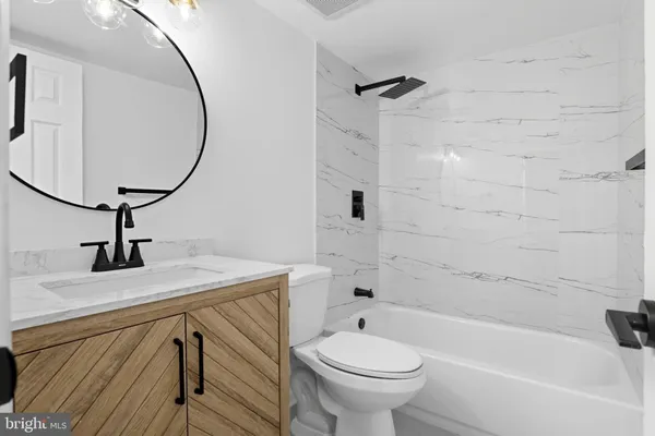 a bathroom with a sink a toilet and bathtub