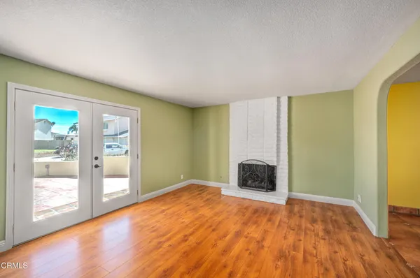 a view of empty room with wooden floor and fireplace