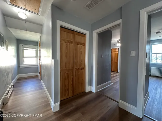 a view of a hallway with wooden floor and glass door