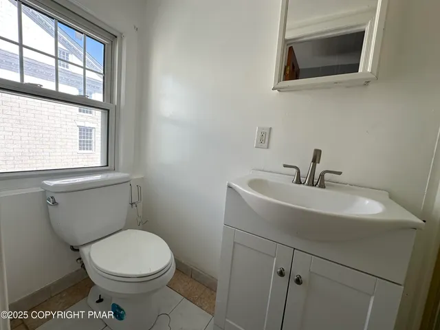 a bathroom with a sink a toilet and a window