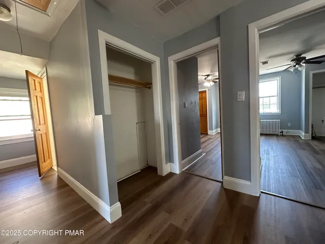 a view of a hallway with wooden floor and stairs