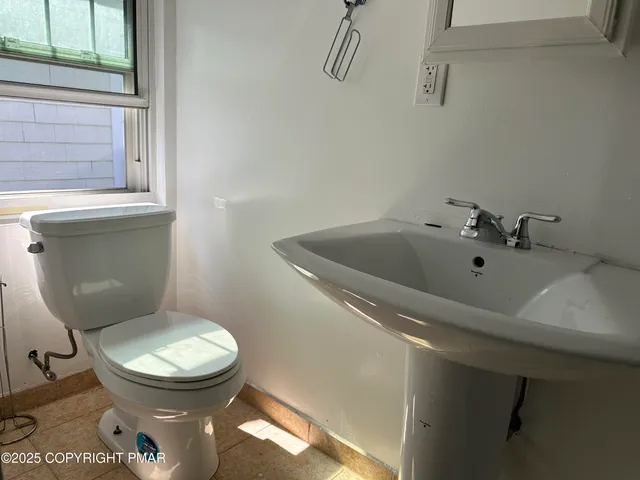 a white toilet sitting next to a bathroom sink