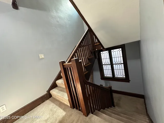 a view of staircase with wooden floor and a window