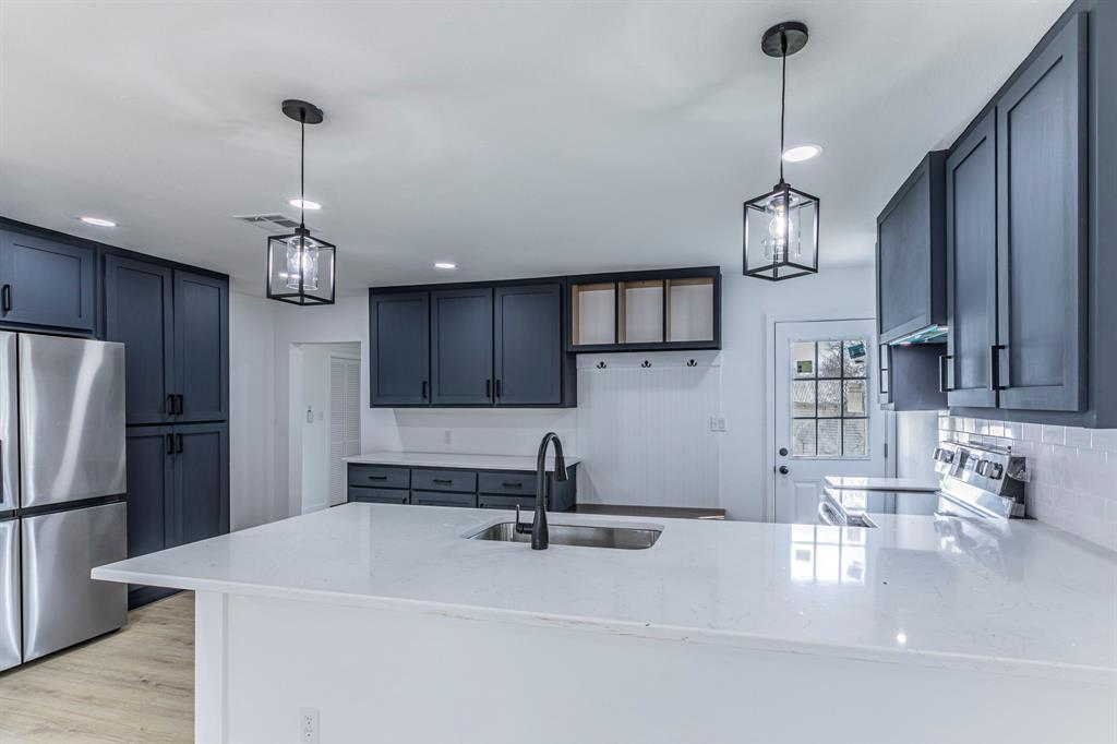 1026 La Clede Street Bellmead, TX 76705 - Photo 5 of 27 a kitchen with kitchen island stainless steel appliances a sink cabinets a refrigerator and a sink