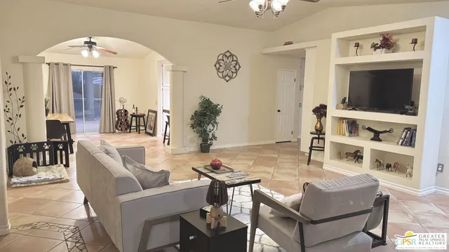 a view of a livingroom with furniture and a chandelier fan