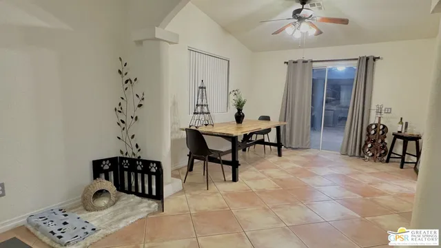 a kitchen with stainless steel appliances kitchen island granite countertop a table chairs and a refrigerator