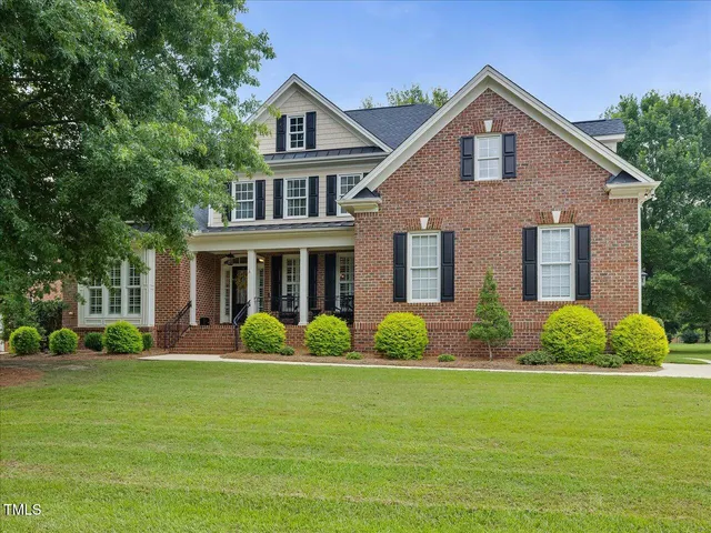 a front view of a house with garden and porch