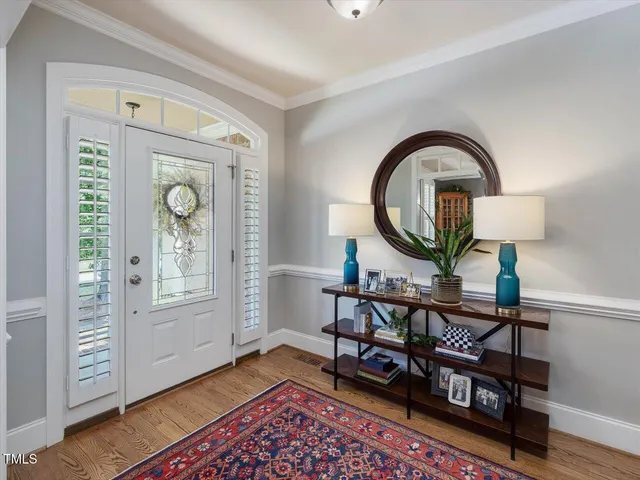 a view of a dining room with furniture a chandelier and wooden floor