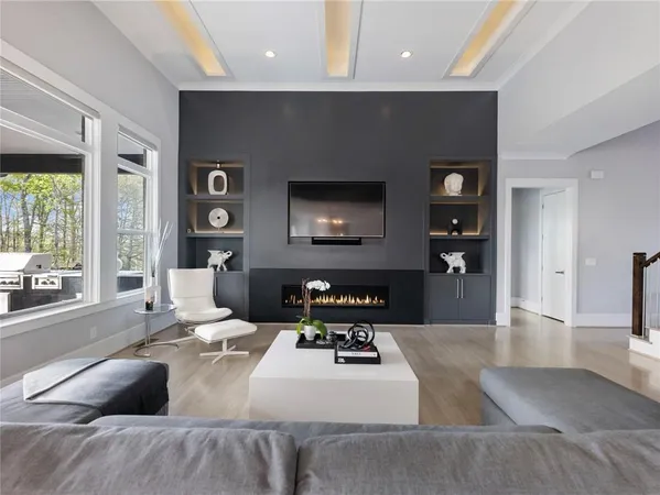 a living room with furniture kitchen view and a large window