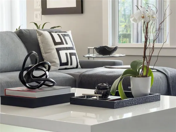 a living room with stainless steel appliances furniture and a kitchen view