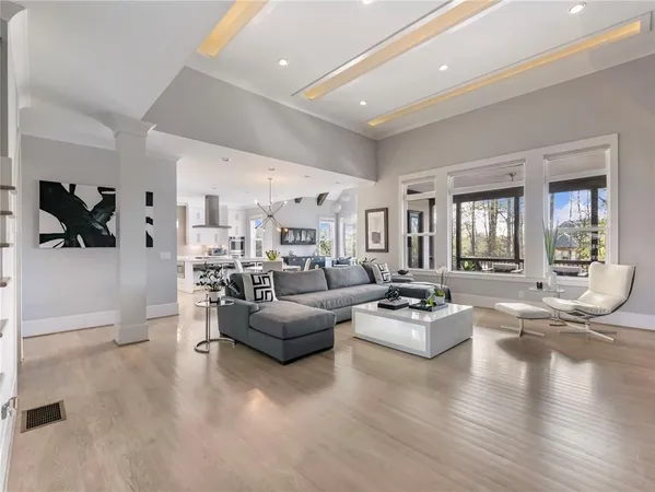 a living room with furniture a wooden floor and a chandelier