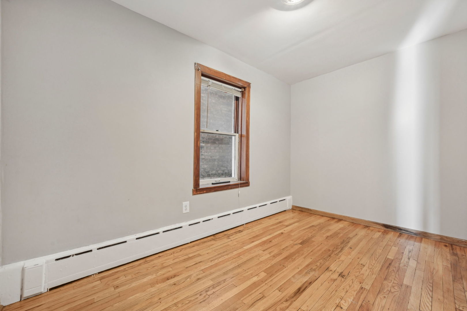 3140 West Pershing Road Chicago, IL 60632 - Photo 12 of 65 an empty room with wooden floor and windows