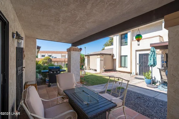 a view of a patio with table and chairs potted plants and floor to ceiling window