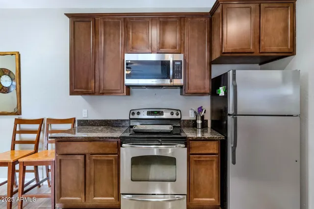 a kitchen with stainless steel appliances granite countertop a stove a microwave and a refrigerator