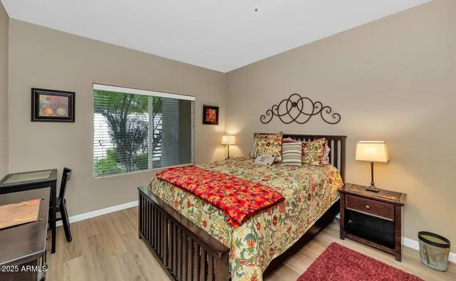 a bedroom with a bed and a window with lamp