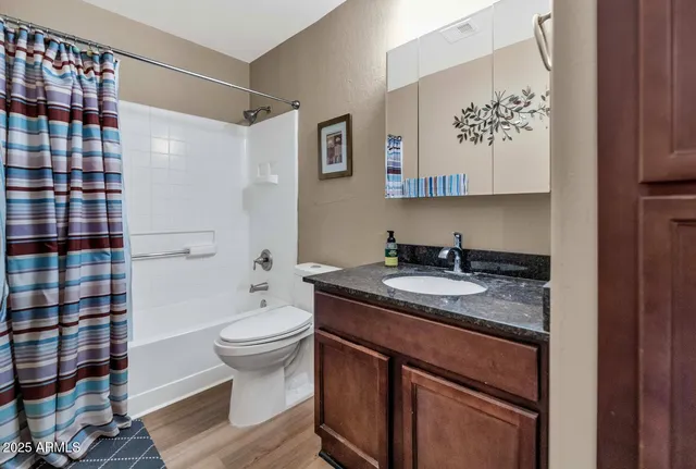 a bathroom with a granite countertop sink a toilet and a shower