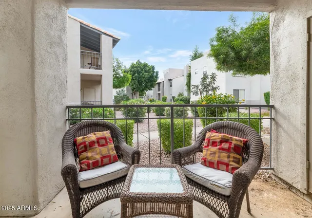 an outdoor living room with furniture and a floor to ceiling window