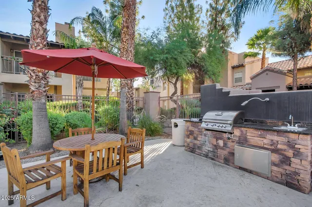 a view of a patio with a table and chairs under an umbrella