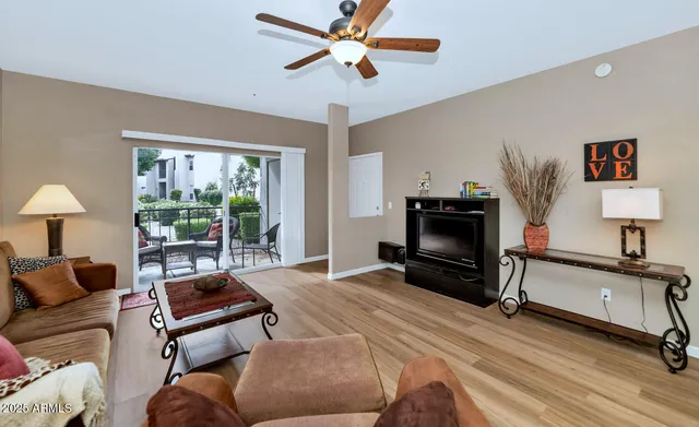 a living room with furniture a flat screen tv and a large window
