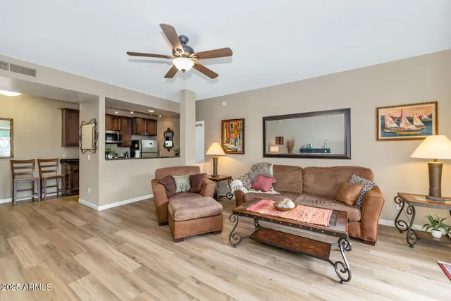 a living room with furniture and a view of kitchen