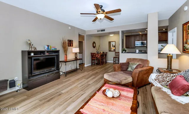a living room with furniture a flat screen tv and a fireplace
