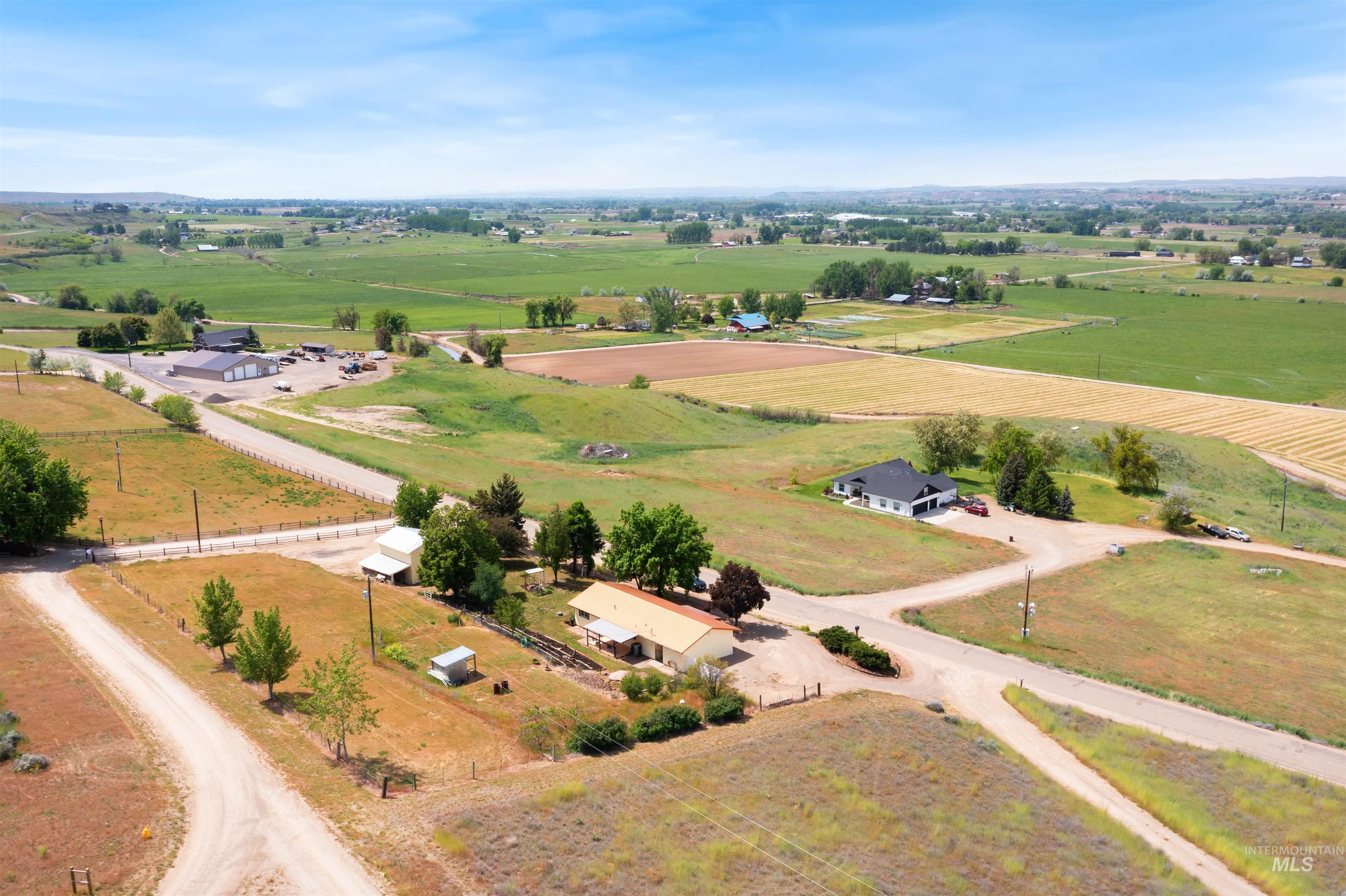 12184 Hill Road Payette, ID 83661 - Photo 1 of 35 Expansive agricultural land featuring a black-roofed residence, a separate commercial structure with gray siding, and surrounding cultivated fields