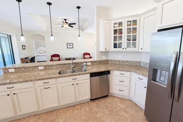 a kitchen with stainless steel appliances granite countertop a sink and dishwasher with white cabinets