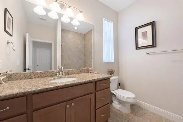 a bathroom with a granite countertop sink mirror and toilet