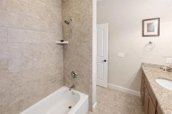 a bathroom with a granite countertop sink a toilet and shower