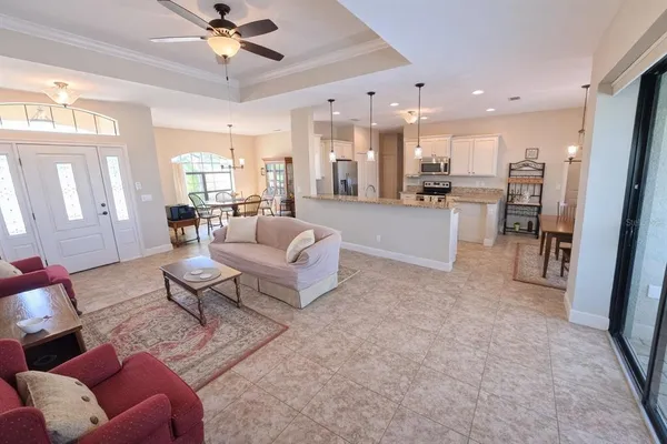 a living room with furniture and a view of kitchen