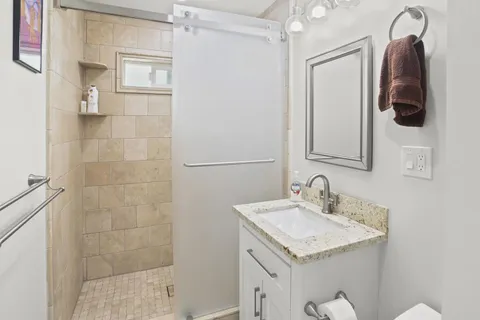a bathroom with a granite countertop sink and a mirror