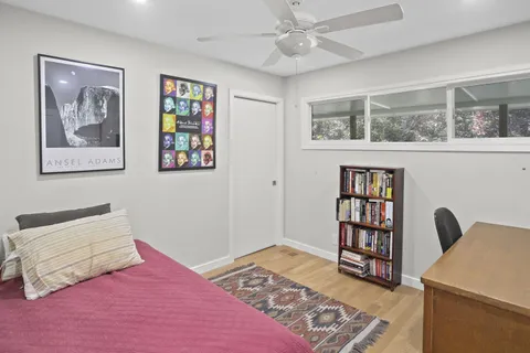 a bedroom with a bed a dresser and book shelf