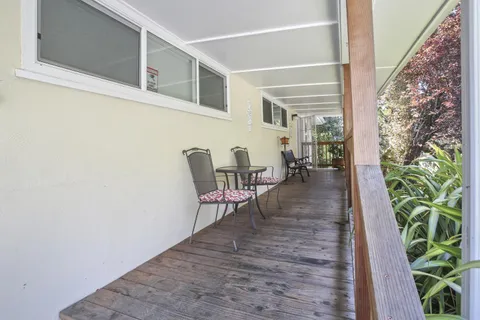 a view of a patio with table and chairs with wooden floor and plants