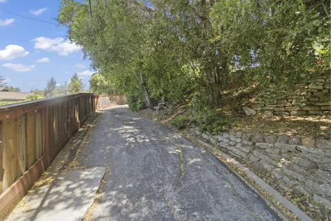 a view of a yard with wooden fence