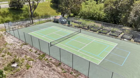 a view of a tennis court with large trees